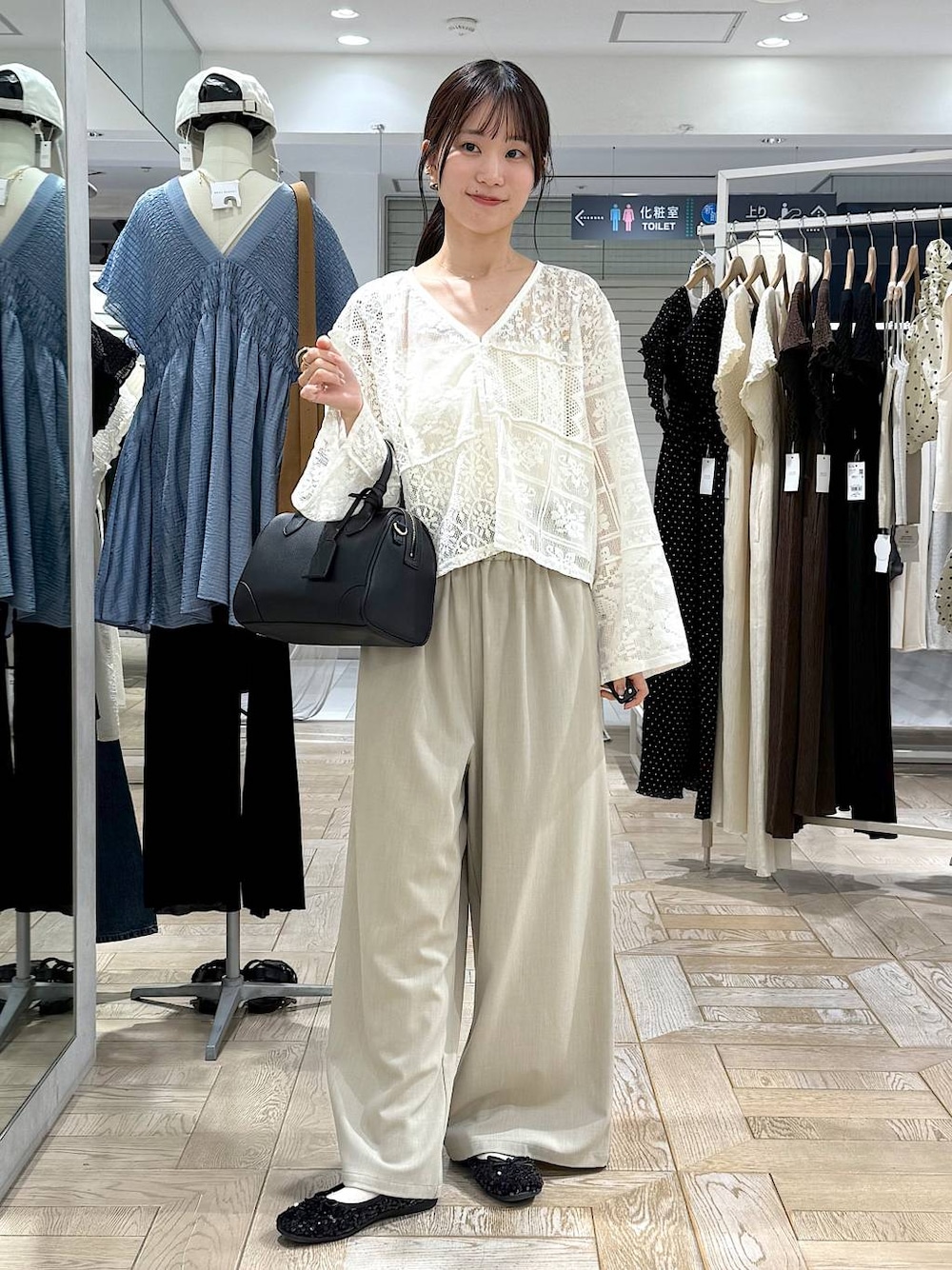 ブラック系のショルダーバッグ、ホワイト系のカーディガン/ボレロ、ゴールド系のバレッタ/ヘアクリップを着用したレディースの秋コーディネートの1枚目の写真