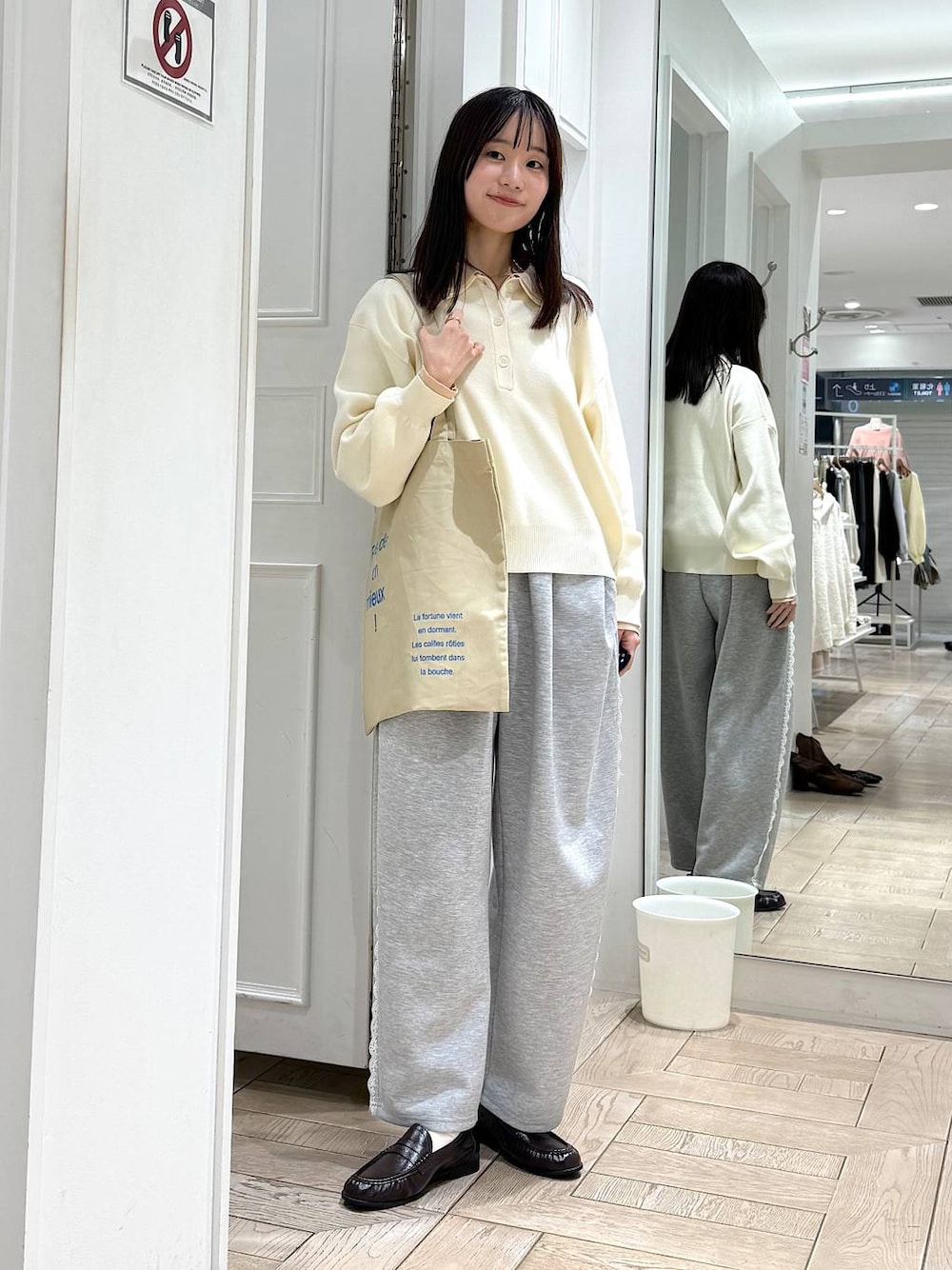 グレー系のスウェットパンツ、ホワイト系のニット/セーター、ベージュ系のトートバッグを着用したレディースの冬コーディネートの1枚目の写真