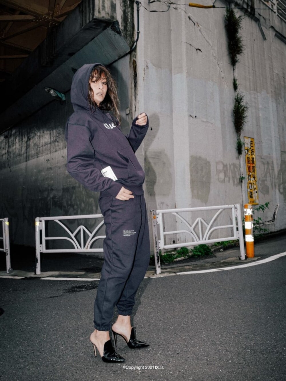 ブラック系のパーカー、ブルー系のスウェットパンツを着用したレディースの秋コーディネートの1枚目の写真