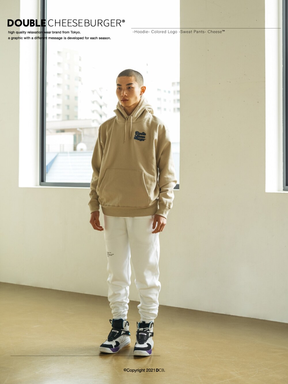 ベージュ系のパーカー、ホワイト系のスウェットパンツを着用したメンズの春コーディネートの1枚目の写真