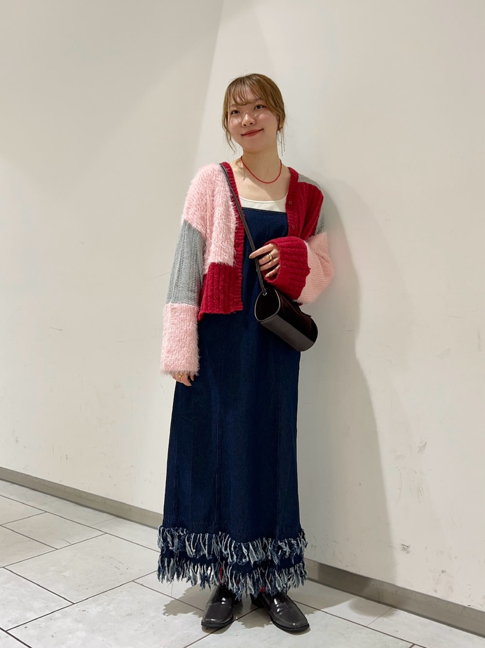 レッド系のカーディガン/ボレロ、ブラウン系のショルダーバッグ、ブルー系のワンピースを着用したレディースの秋コーディネートの1枚目の写真