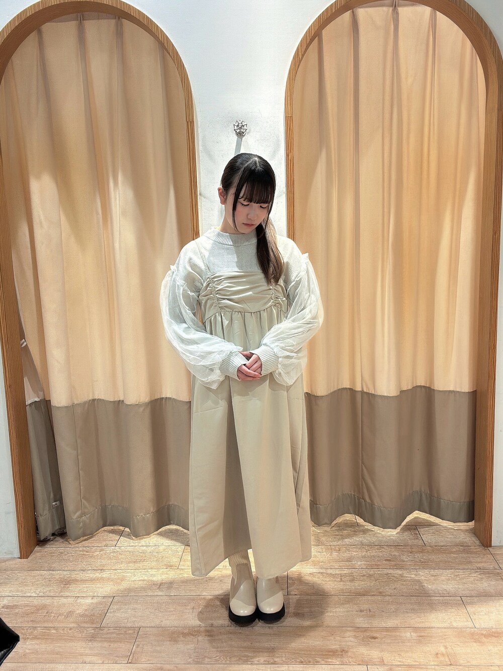 ホワイト系のニット/セーター、ベージュ系のワンピース、ベージュ系のブーツを着用したレディースの秋コーディネートの1枚目の写真