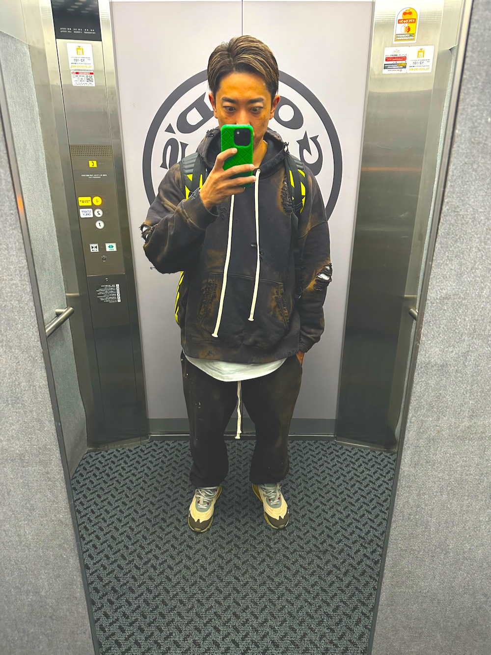 ベージュ系のスニーカー、ブラック系のパーカー、ブラック系のスウェットパンツを着用したメンズの秋コーディネートの1枚目の写真