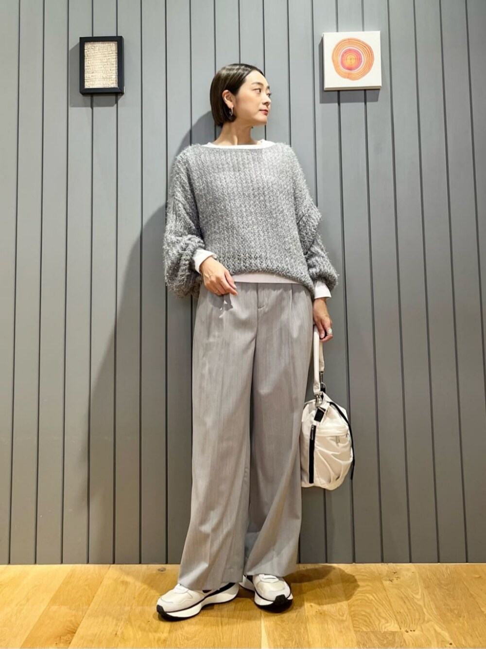 ホワイト系のショルダーバッグ、グレー系のニット/セーター、ホワイト系のTシャツ/カットソーを着用したレディースの秋コーディネートの1枚目の写真
