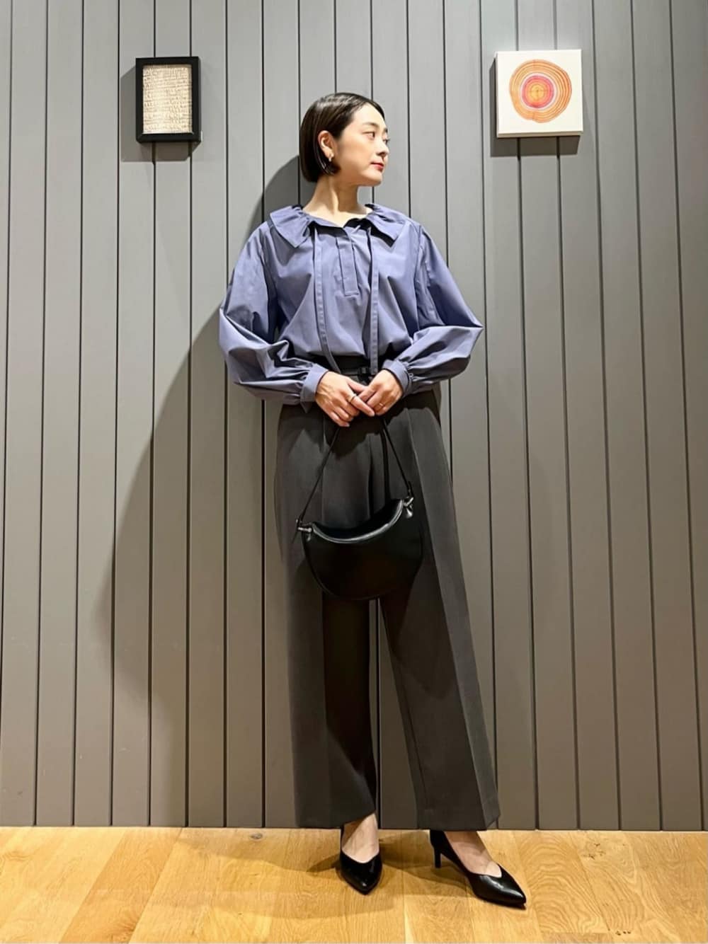 ブラック系のパンプス、グレー系のスラックス、ブルー系のシャツ/ブラウスを着用したレディースの秋コーディネートの1枚目の写真