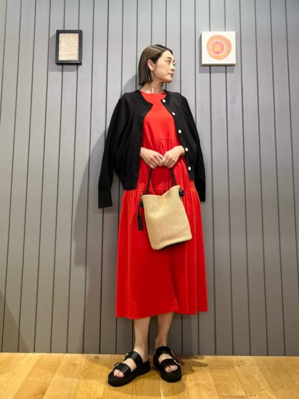 ブラック系のカーディガン/ボレロ、ベージュ系のトートバッグ、レッド系のワンピースを着用したレディースの春コーディネートの1枚目の写真