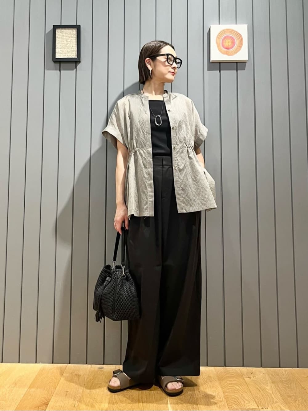 ブラウン系のシャツ/ブラウス、ブラック系のタンクトップ、ブラック系のスラックスを着用したレディースの夏コーディネートの1枚目の写真