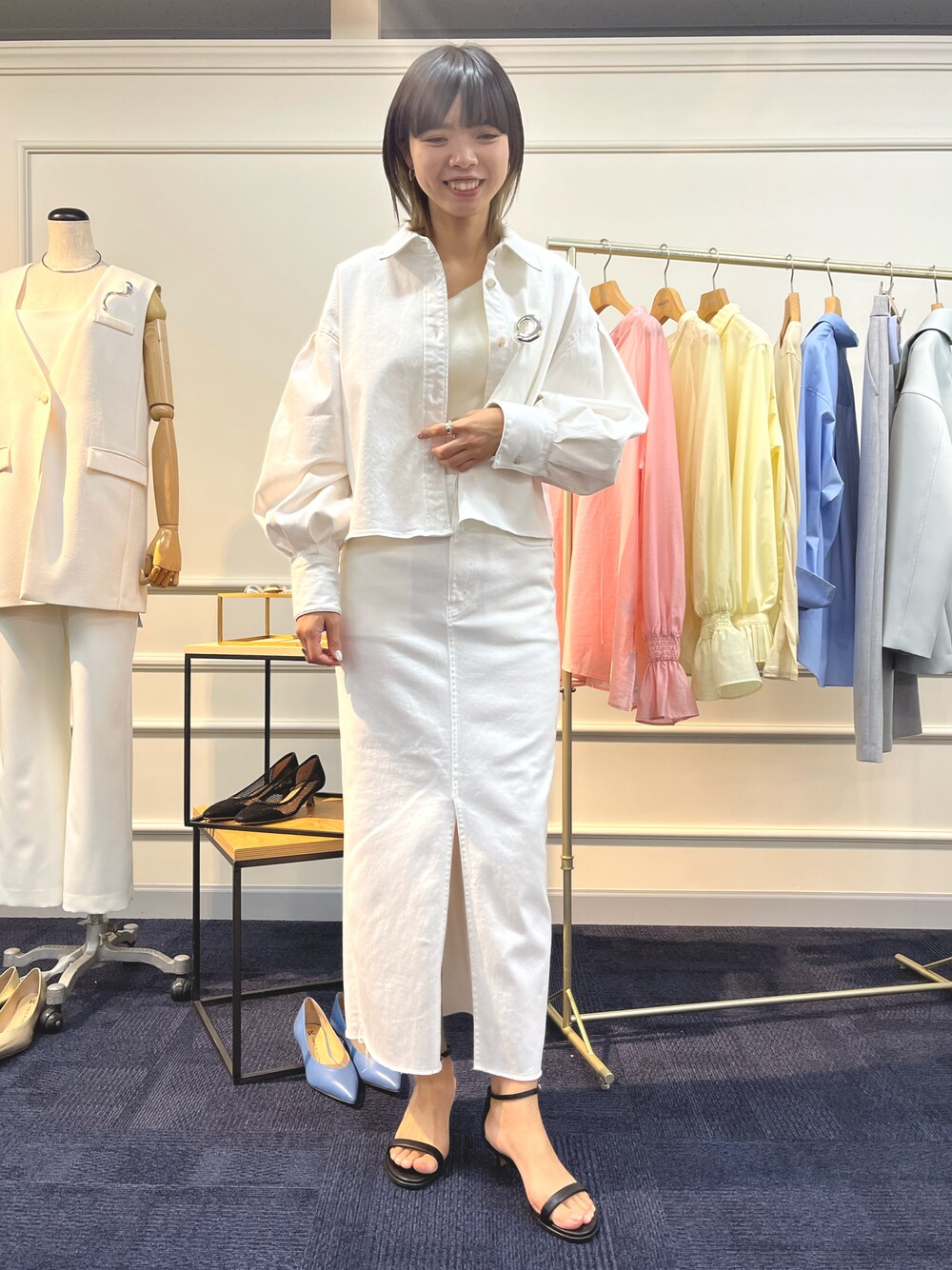 ホワイト系のシャツ/ブラウス、ホワイト系のデニムスカート、ブラック系のサンダルを着用したレディースの夏コーディネートの1枚目の写真