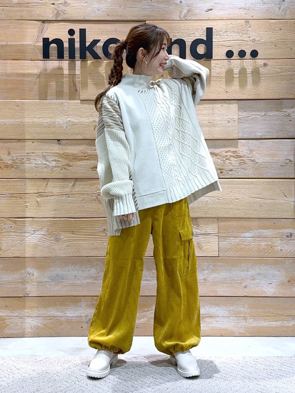 ベージュ系のブーツ、イエロー系のカーゴパンツ、ホワイト系のニット/セーターを着用したレディースの秋コーディネートの1枚目の写真