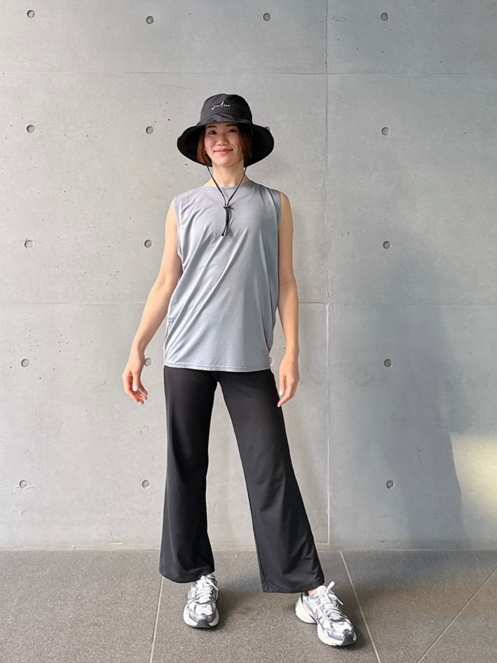 グレー系のタンクトップ、ブラック系のレギンス/スパッツを着用したレディースの春コーディネートの1枚目の写真
