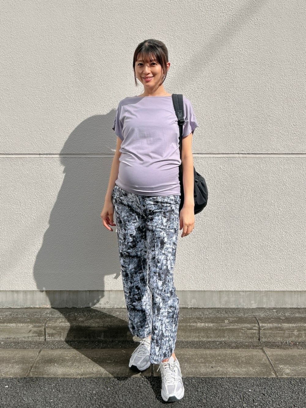 ブラック系のバックパック/リュック、パープル系のTシャツ/カットソー、グレー系のレギンス/スパッツを着用したレディースの秋コーディネートの1枚目の写真