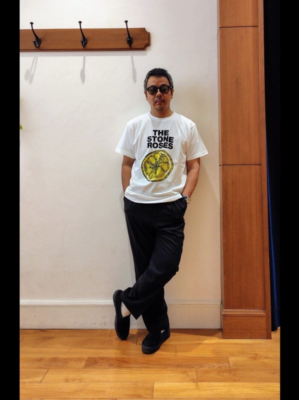 ホワイト系のTシャツ/カットソー、ブラック系のスラックス、ブラック系のサングラスを着用したメンズの春コーディネートの1枚目の写真