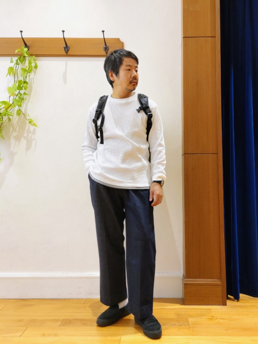 ホワイト系のTシャツ/カットソー、ブラック系のバックパック/リュック、ブルー系のデニムパンツを着用したメンズの冬コーディネートの1枚目の写真