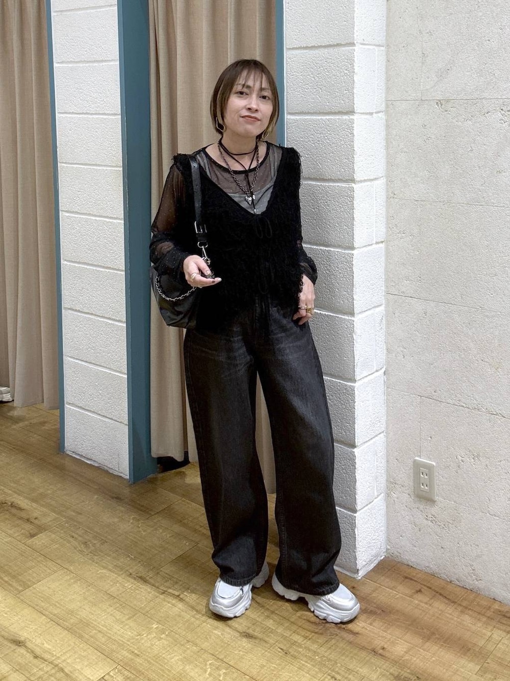 ブラック系のTシャツ/カットソー、ブラック系のデニムパンツ、シルバー系のスニーカーを着用したレディースの冬コーディネートの1枚目の写真