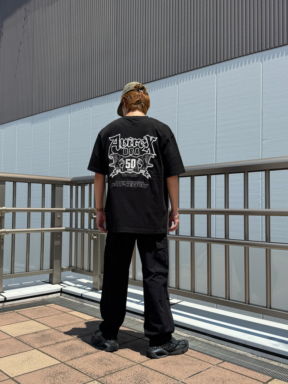 「ミリタリー、ストリート、AVIREX、オールブラック、カーゴパンツ、黒Tシャツ、アビレックス(AVIREX)、AVIREX海老名、AVIREX海老名店、AVIREXららぽーと海老名」｜「AVIREXの《50th Anniversary》GRAPHIC S/S T-SHIRT / 50周年 グラフィック 半袖Tシャツ / AVIREX / アヴィレックス（Tシャツ/カットソー、ブラック系）」を使った、リュウノスケさん（メンズ・169cm）の夏コーディネートの1枚目の写真