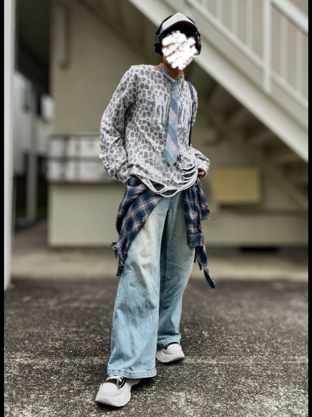 ブラック系のスニーカー、ホワイト系のTシャツ/カットソー、ブルー系のデニムパンツを着用したメンズの秋コーディネートの1枚目の写真