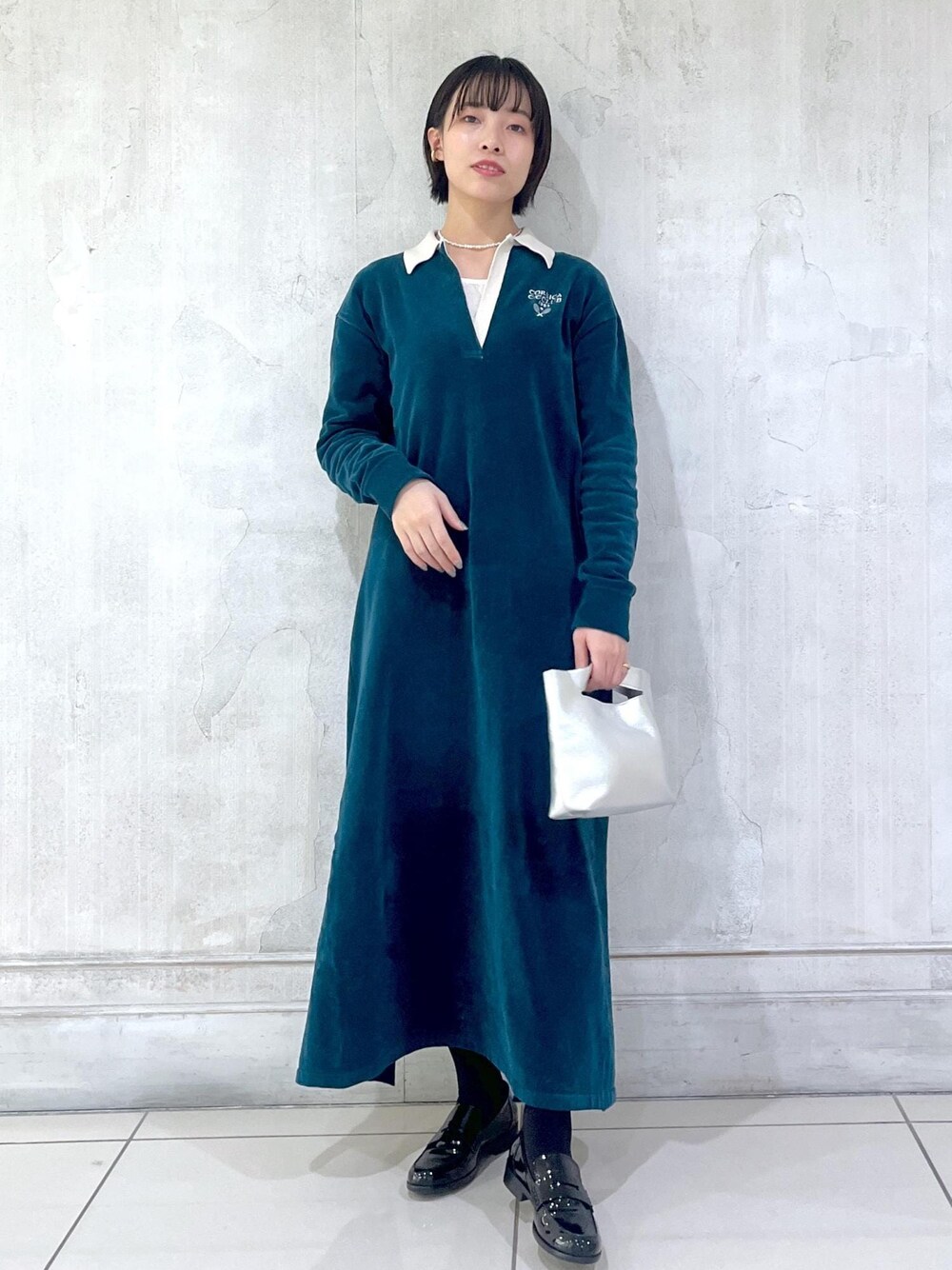 グリーン系のワンピースを着用したレディースの冬コーディネートの1枚目の写真