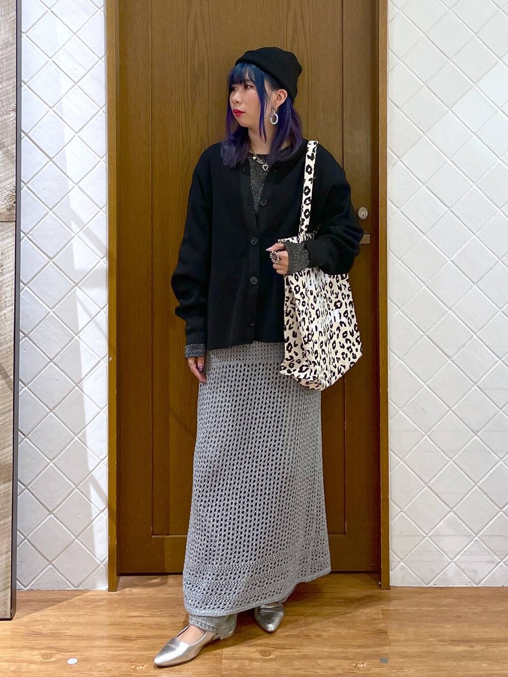 グレー系のデニムパンツ、ブラウン系のトートバッグ、シルバー系のパンプスを着用したレディースの秋コーディネートの1枚目の写真