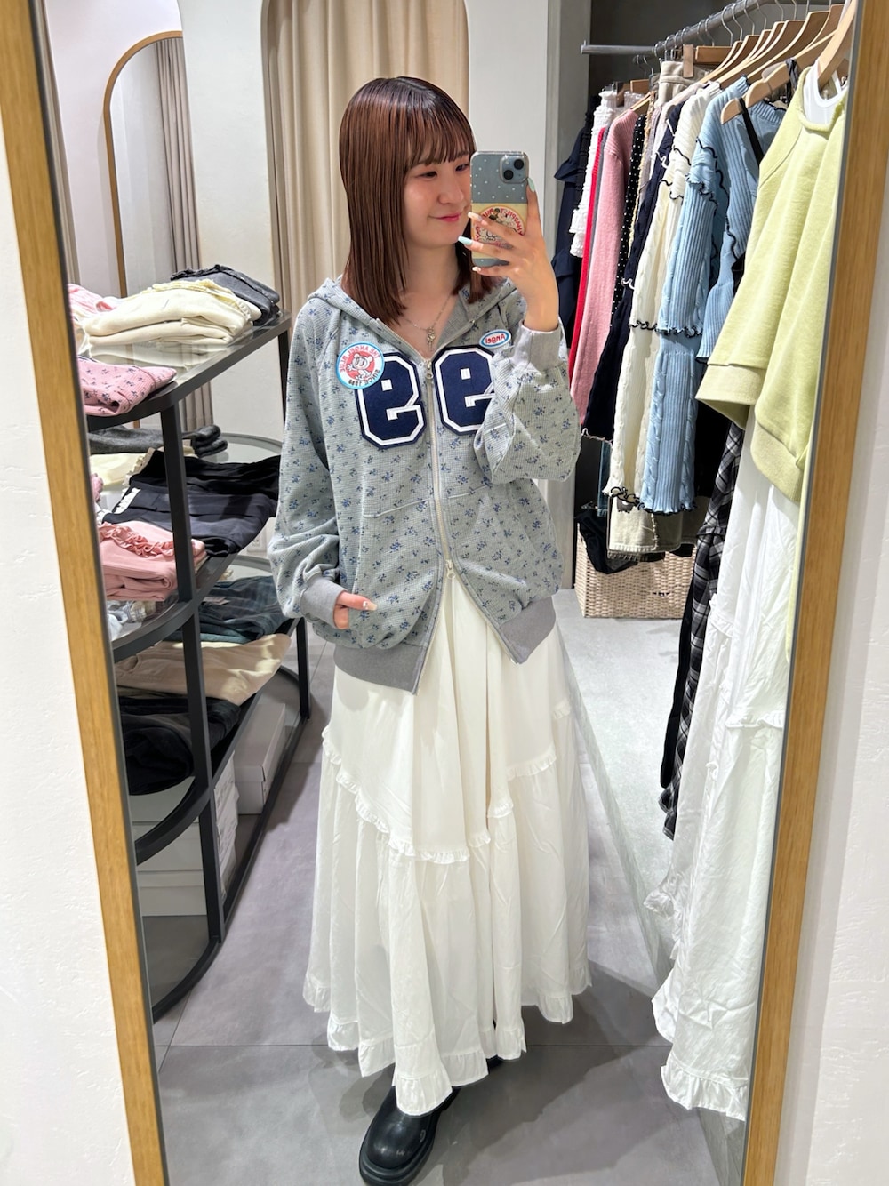 グレー系のパーカー、ホワイト系のワンピースを着用したレディースの春コーディネートの1枚目の写真