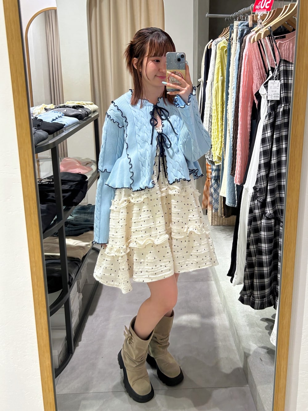 ブルー系のカーディガン/ボレロ、ホワイト系のワンピース、ベージュ系のブーツを着用したレディースの春コーディネートの1枚目の写真