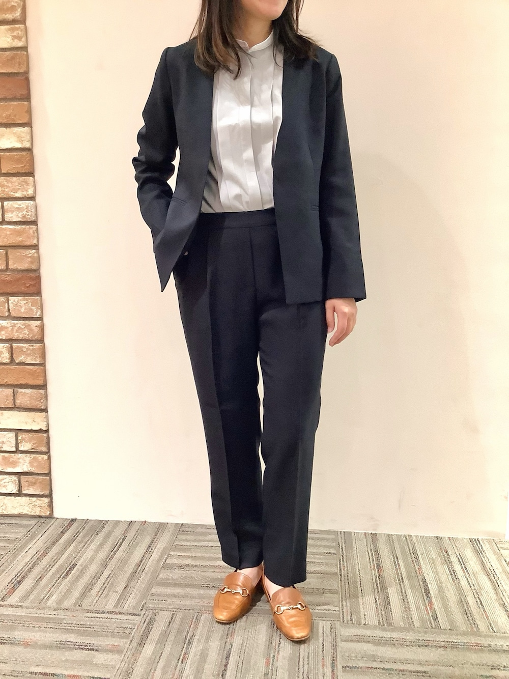 グレー系のシャツ/ブラウス、ブルー系のノーカラージャケット、ブルー系のスラックスを着用したレディースの秋コーディネートの1枚目の写真
