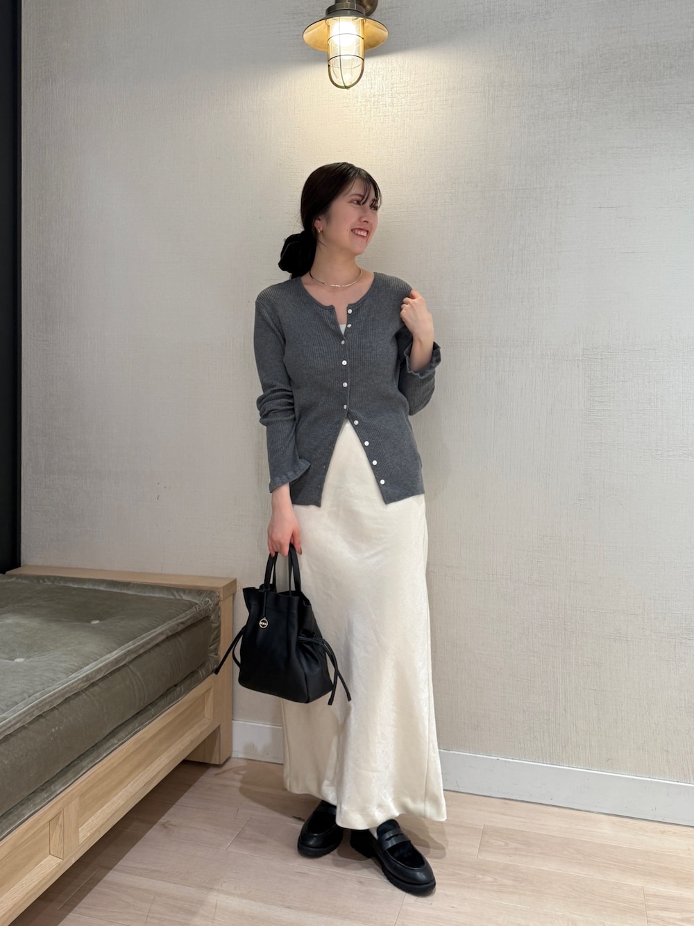 グレー系のカーディガン/ボレロ、ホワイト系のスカート、ブラック系のショルダーバッグを着用したレディースの秋コーディネートの1枚目の写真