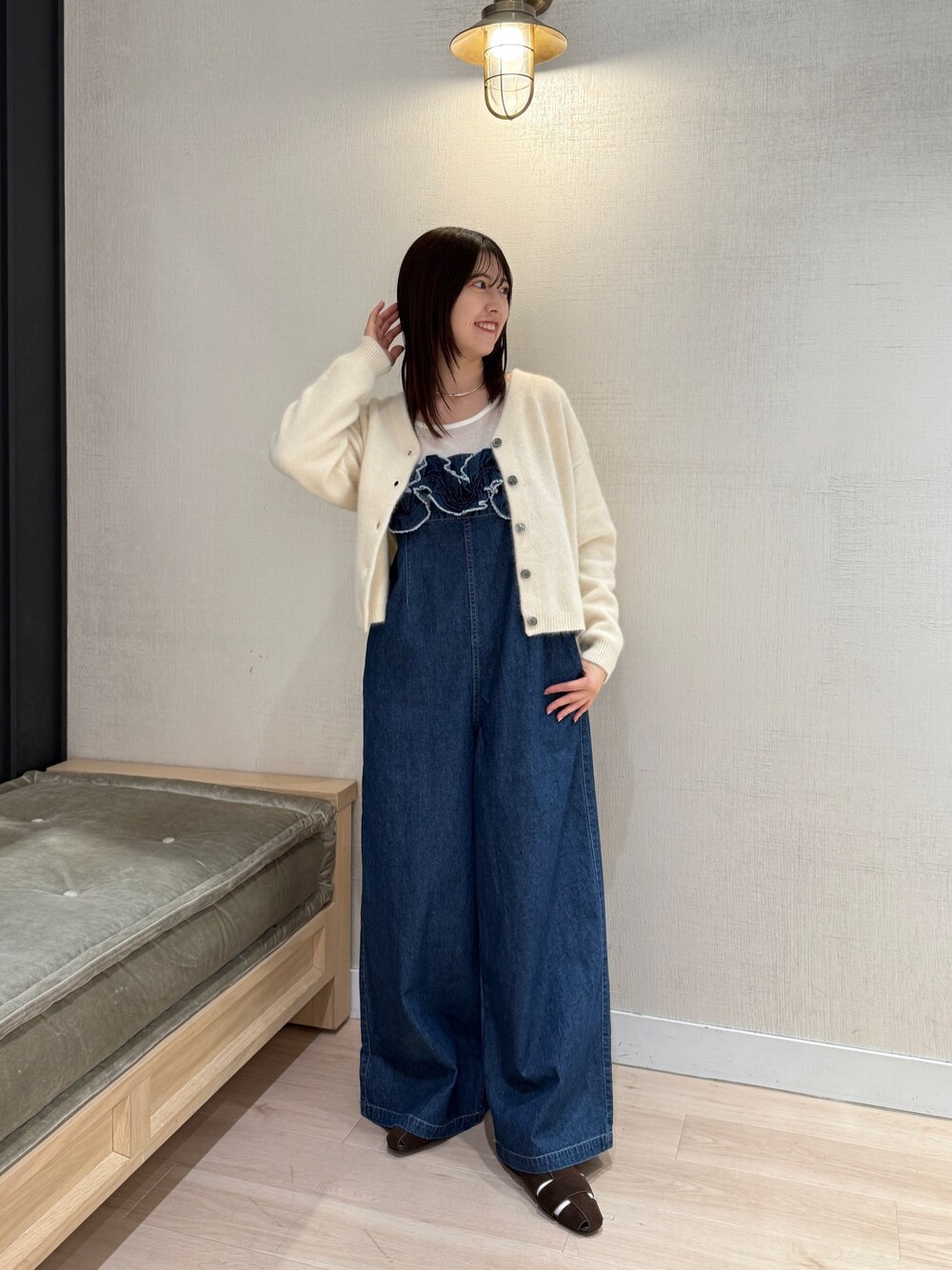 ホワイト系のカーディガン/ボレロ、ブルー系のサロペット/オーバーオール、ブラウン系のパンプスを着用したレディースの秋コーディネートの1枚目の写真