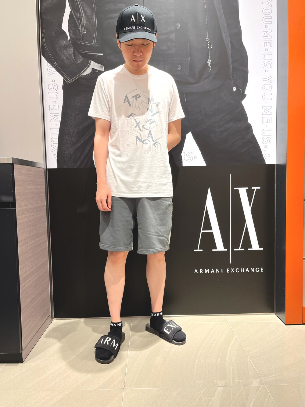 「アルマーニエクスチェンジ、AXchanger、AXchange、夏コーデ、サンダル、ハーフパンツ、Tシャツ」｜「ARMANI EXCHANGEの【A|X アルマーニ エクスチェンジ】グラフィックロゴデザイン　半袖クルーネックTシャツ/SLIM（Tシャツ/カットソー、ホワイト系）」を使った、Riさん（メンズ・175cm）の夏コーディネートの1枚目の写真