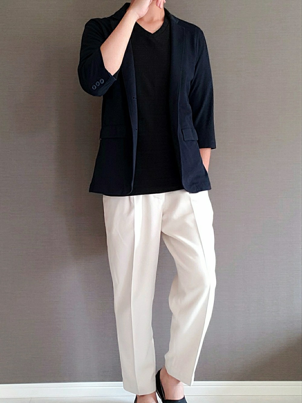 ホワイト系のスラックス、ブラック系のスリッポン、ブラック系のTシャツ/カットソーを着用したメンズの夏コーディネートの1枚目の写真