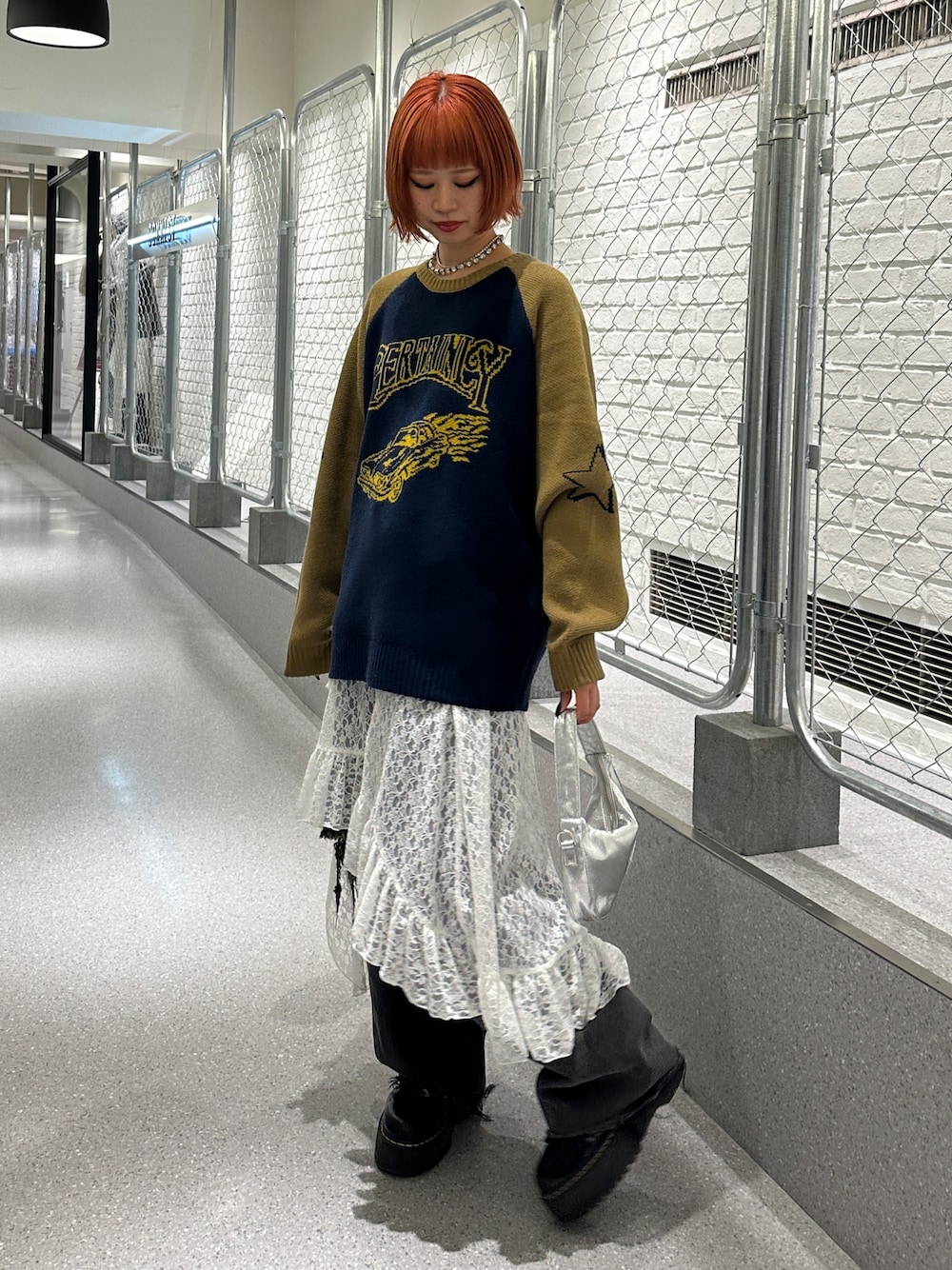 ブルー系のニット/セーター、ホワイト系のスカート、ブラック系のデニムパンツを着用したレディースの冬コーディネートの1枚目の写真