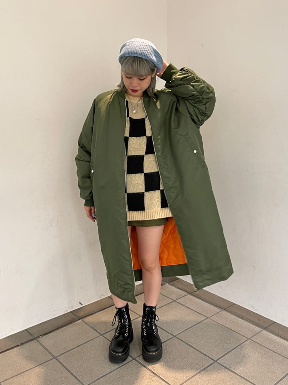 ブラック系のニット/セーター、グリーン系のMA-1、グリーン系のスカートを着用したレディースの秋コーディネートの1枚目の写真