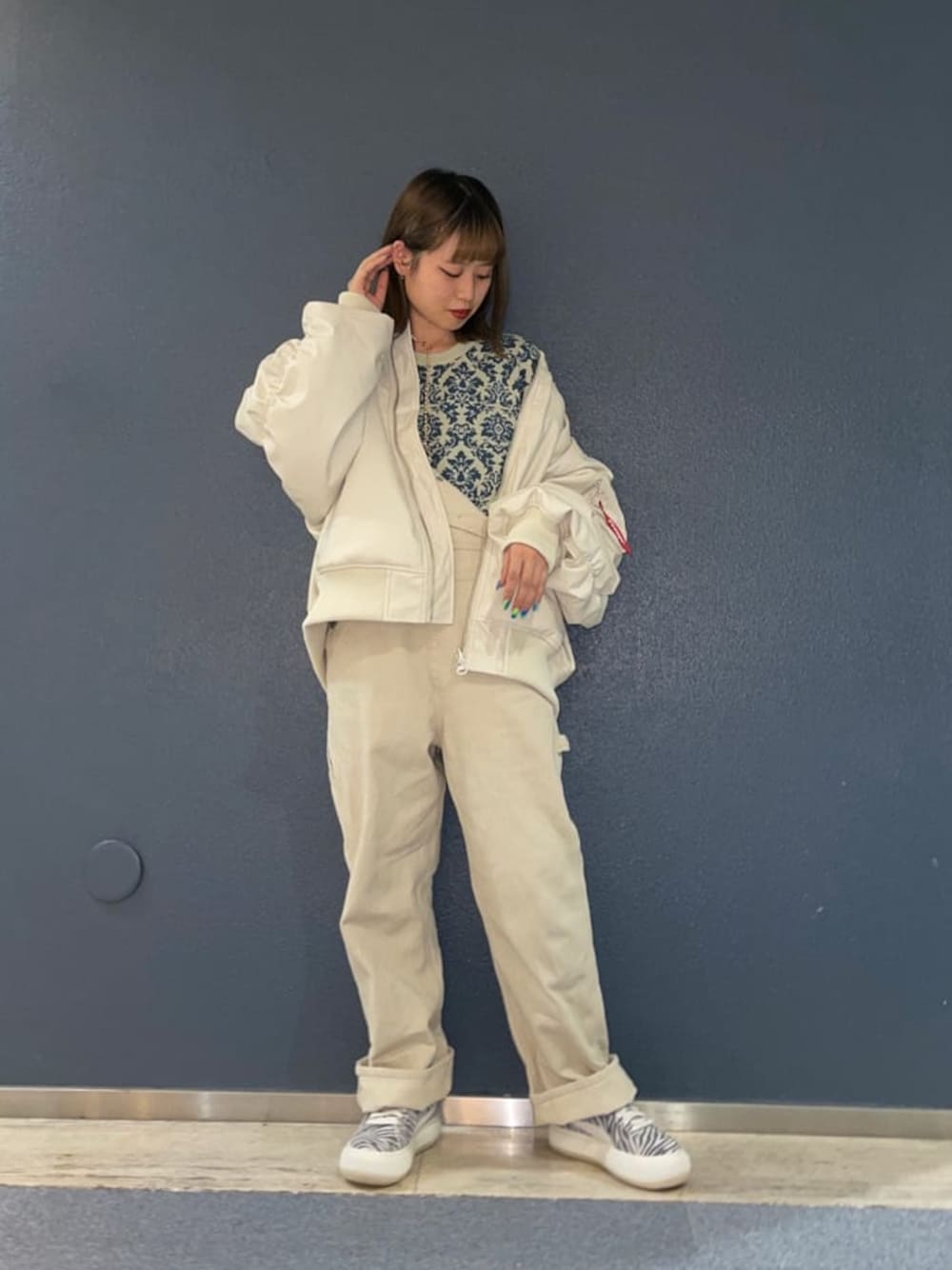 ホワイト系のMA-1、ホワイト系のスニーカー、ホワイト系のサロペット/オーバーオールを着用したレディースの冬コーディネートの1枚目の写真