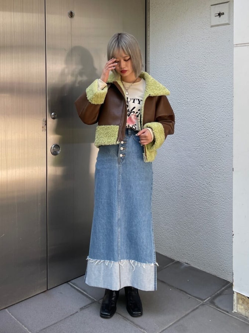 ブラック系のブーツ、ブラウン系のその他アウター、ブルー系のデニムスカートを着用したレディースの夏コーディネートの1枚目の写真