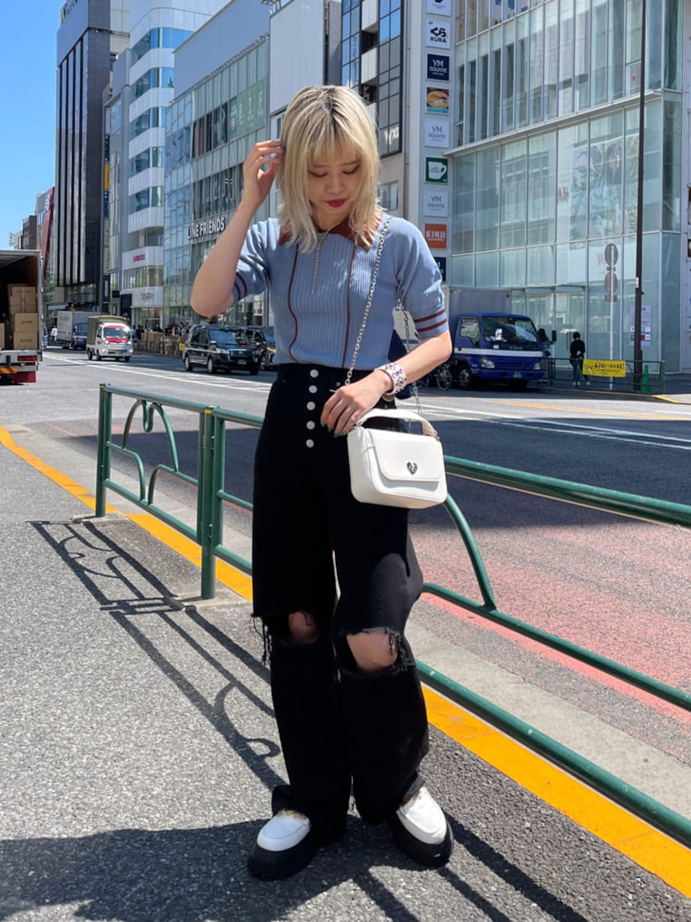 ホワイト系のその他シューズ、ブルー系のニット/セーター、ブラック系のデニムパンツを着用したレディースの春コーディネートの1枚目の写真