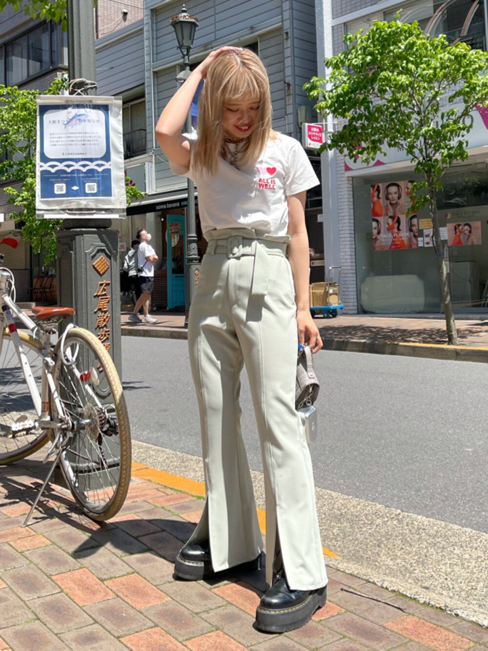 グリーン系のスラックス、その他のショルダーバッグ、ホワイト系のTシャツ/カットソーを着用したレディースの春コーディネートの1枚目の写真