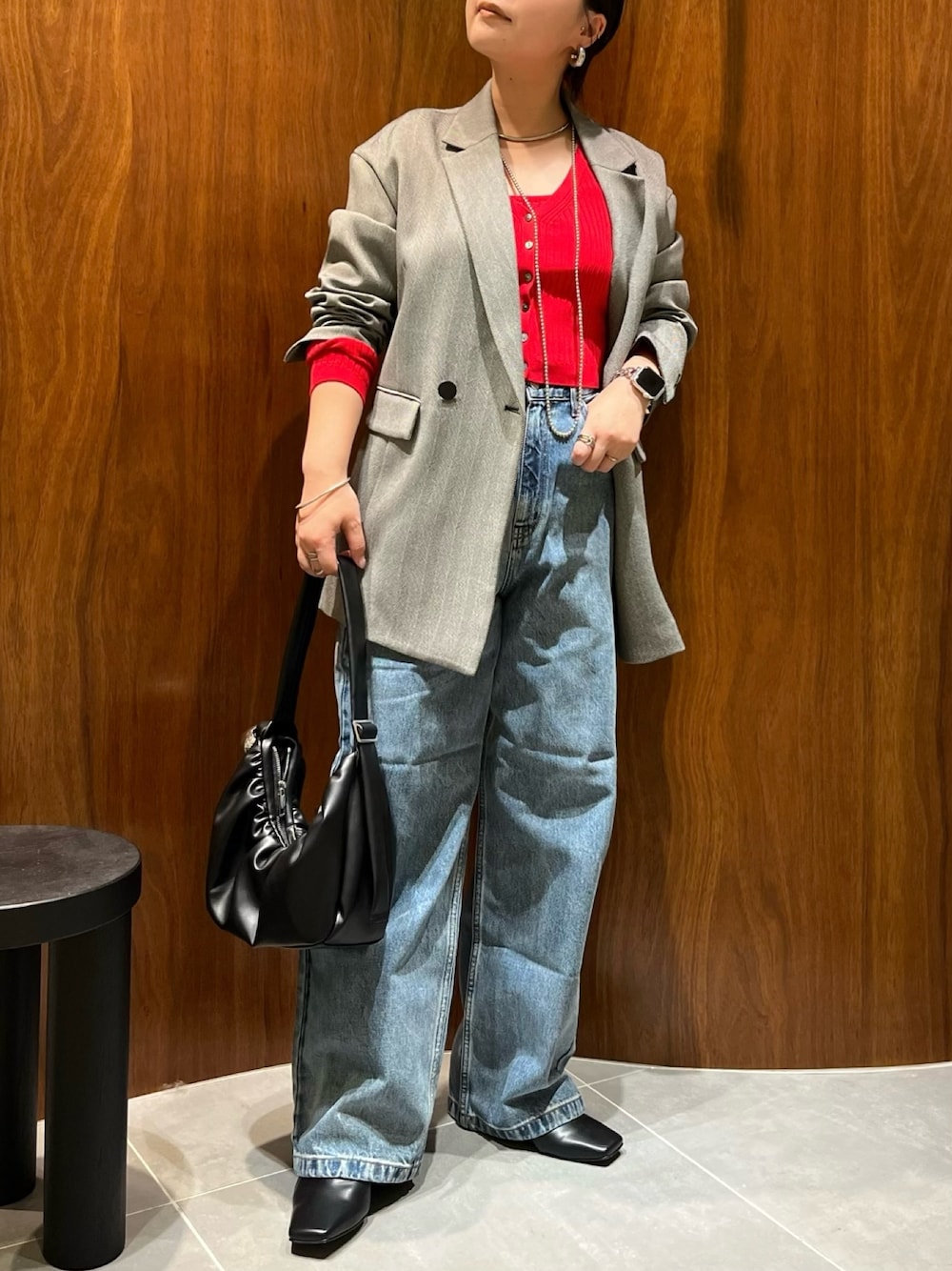 ブラック系のテーラードジャケット、レッド系のカーディガン/ボレロ、ブラック系のハンドバッグを着用したレディースの秋コーディネートの1枚目の写真