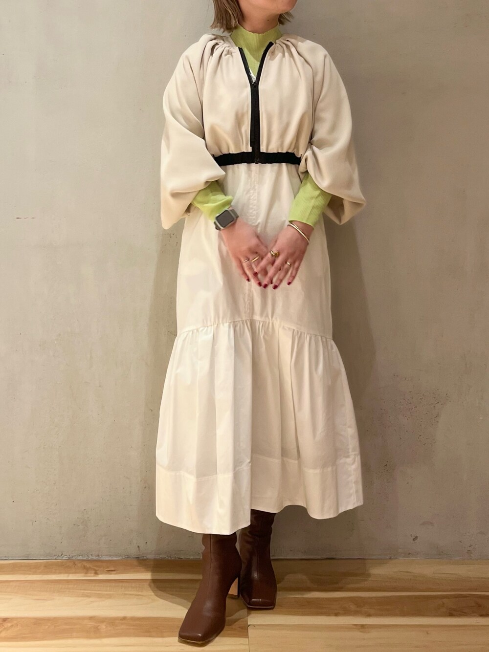 ホワイト系のワンピース、グリーン系のニット/セーターを着用したレディースの冬コーディネートの1枚目の写真