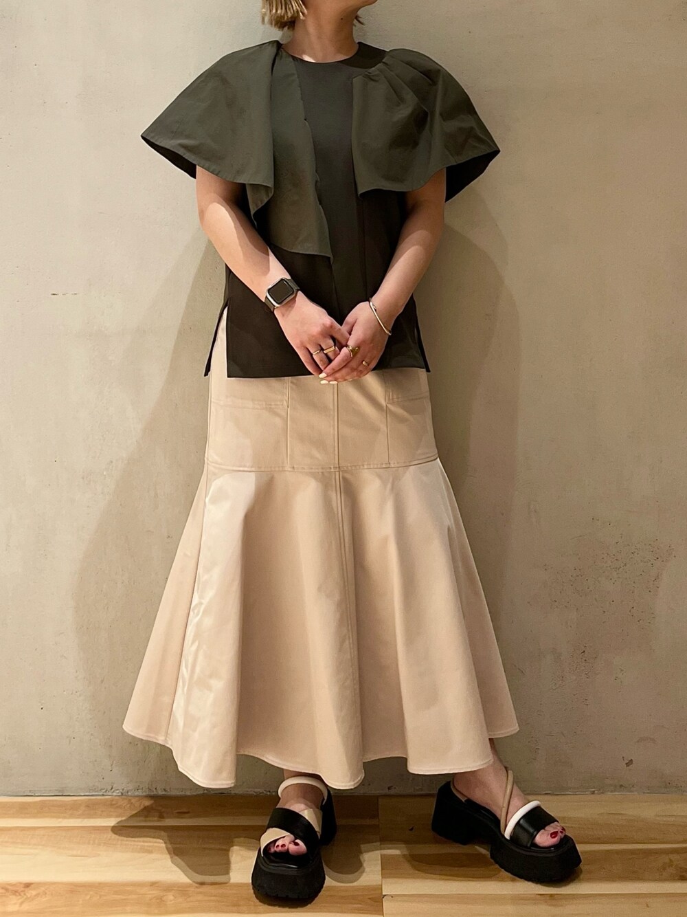 グリーン系のTシャツ/カットソー、ベージュ系のスカート、その他のサンダルを着用したレディースの春コーディネートの1枚目の写真