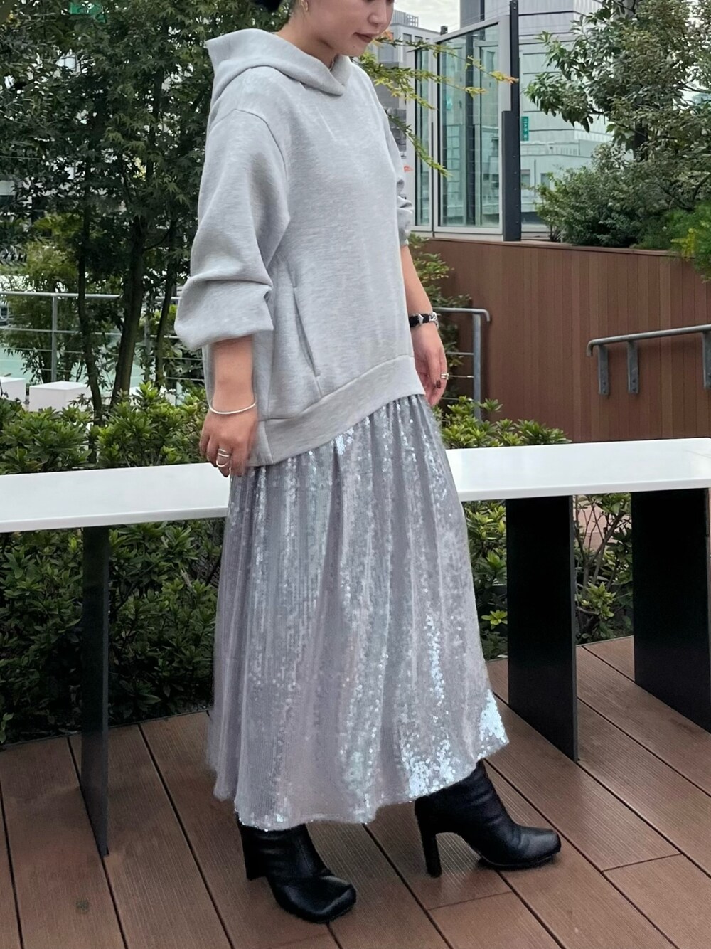 グレー系のワンピース、ブラック系のブーツを着用したレディースの秋コーディネートの1枚目の写真