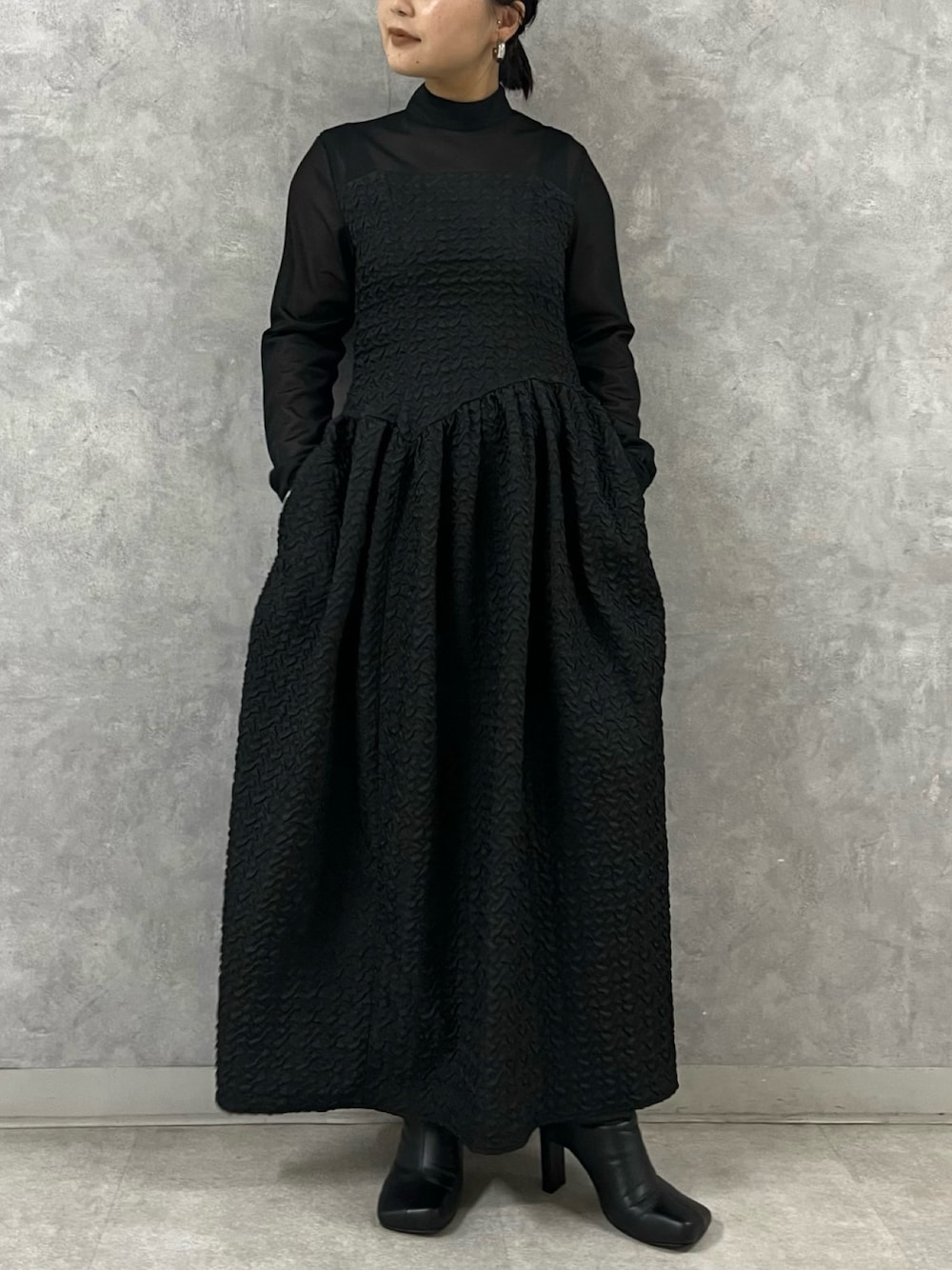 ブラック系のワンピース、ブラック系のブーツを着用したレディースの秋コーディネートの1枚目の写真