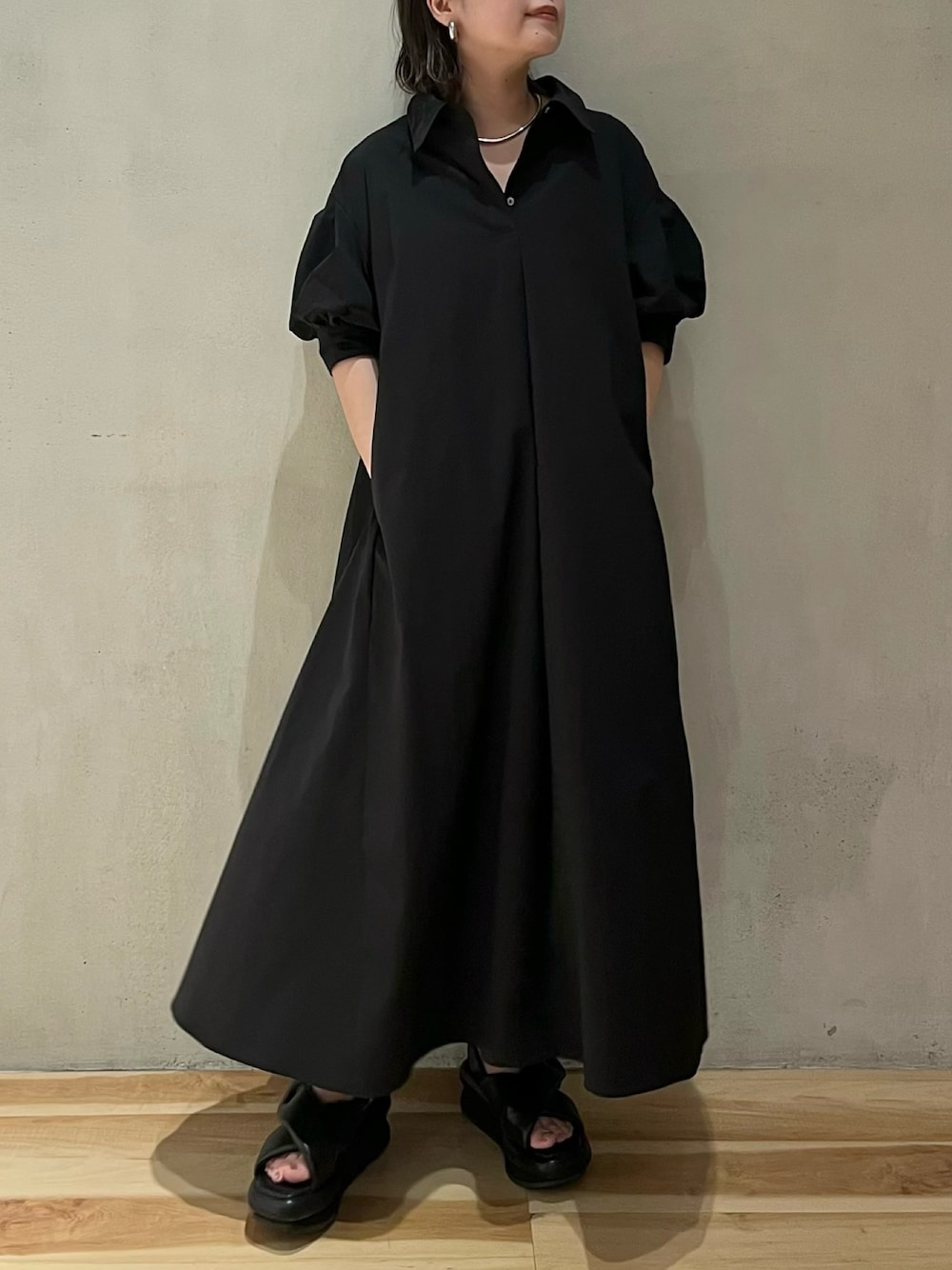 ブラック系のワンピースを着用したレディースの夏コーディネートの1枚目の写真