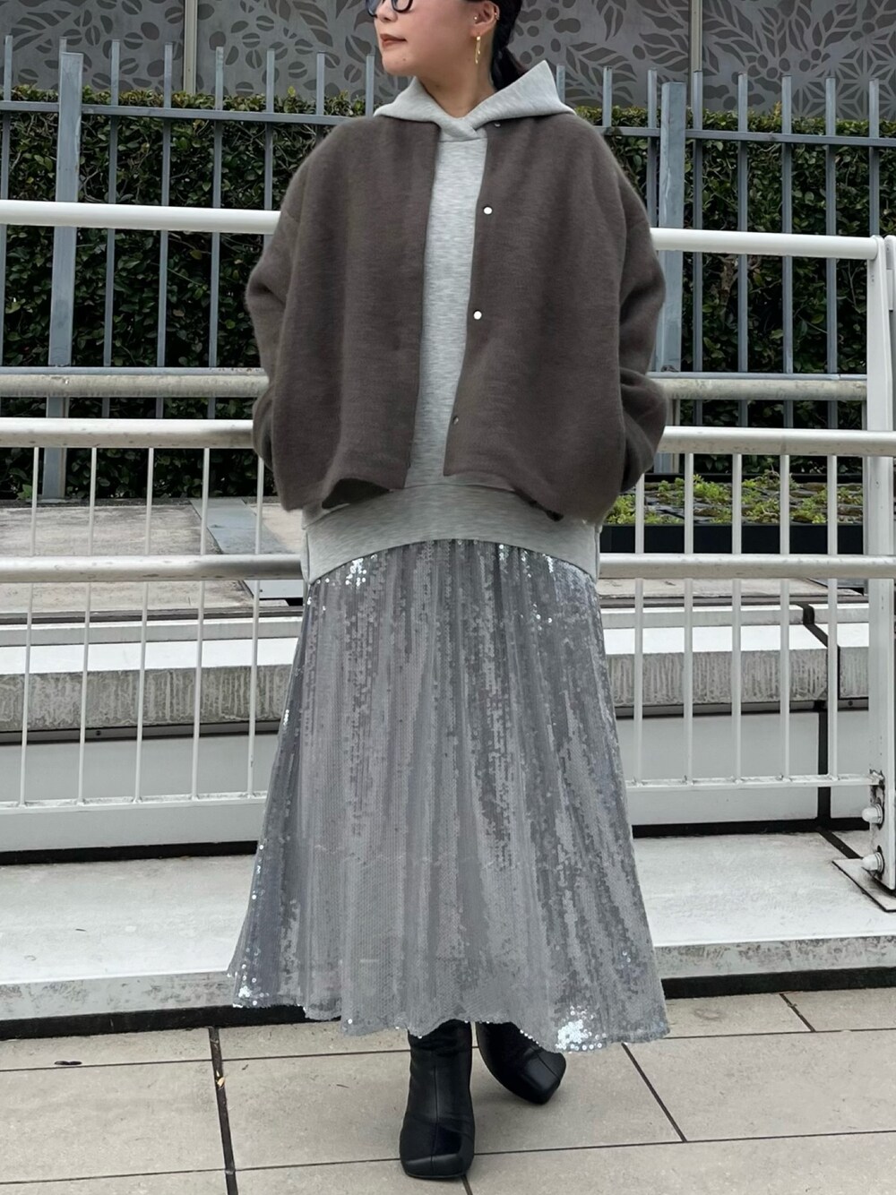 ブラウン系のカーディガン/ボレロ、グレー系のワンピース、ブラック系のブーツを着用したレディースの秋コーディネートの1枚目の写真