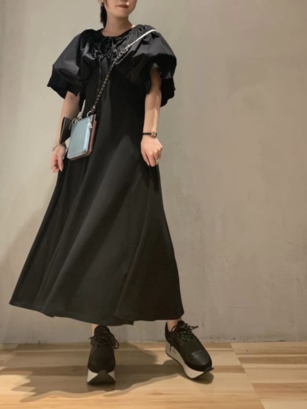 ブラック系のワンピース、ブラウン系のショルダーバッグを着用したレディースの夏コーディネートの1枚目の写真