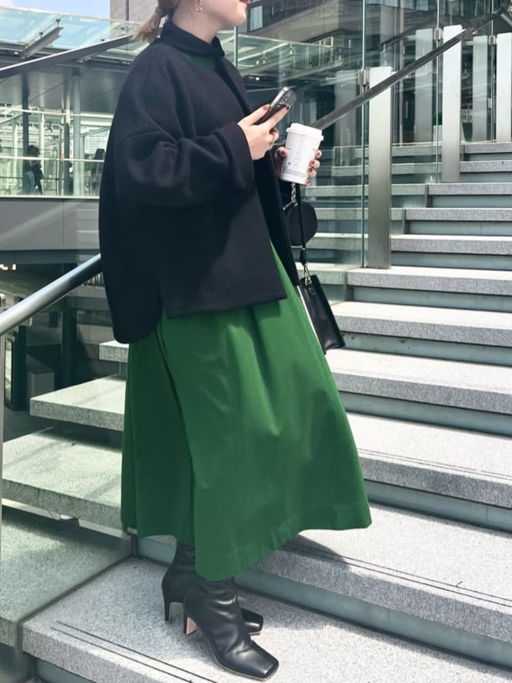 グリーン系のワンピース、ホワイト系のショルダーバッグ、ブラック系のノーカラーコートを着用したレディースの夏コーディネートの1枚目の写真