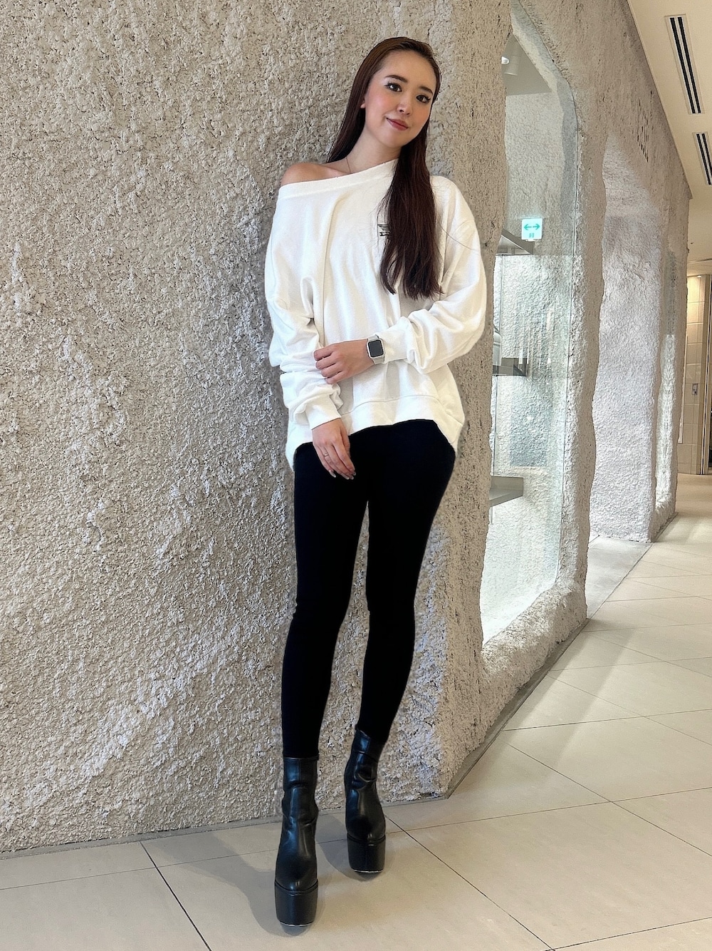 ホワイト系のスウェット、ブラック系のデニムパンツ、ブラック系のブーツを着用したレディースの秋コーディネートの1枚目の写真