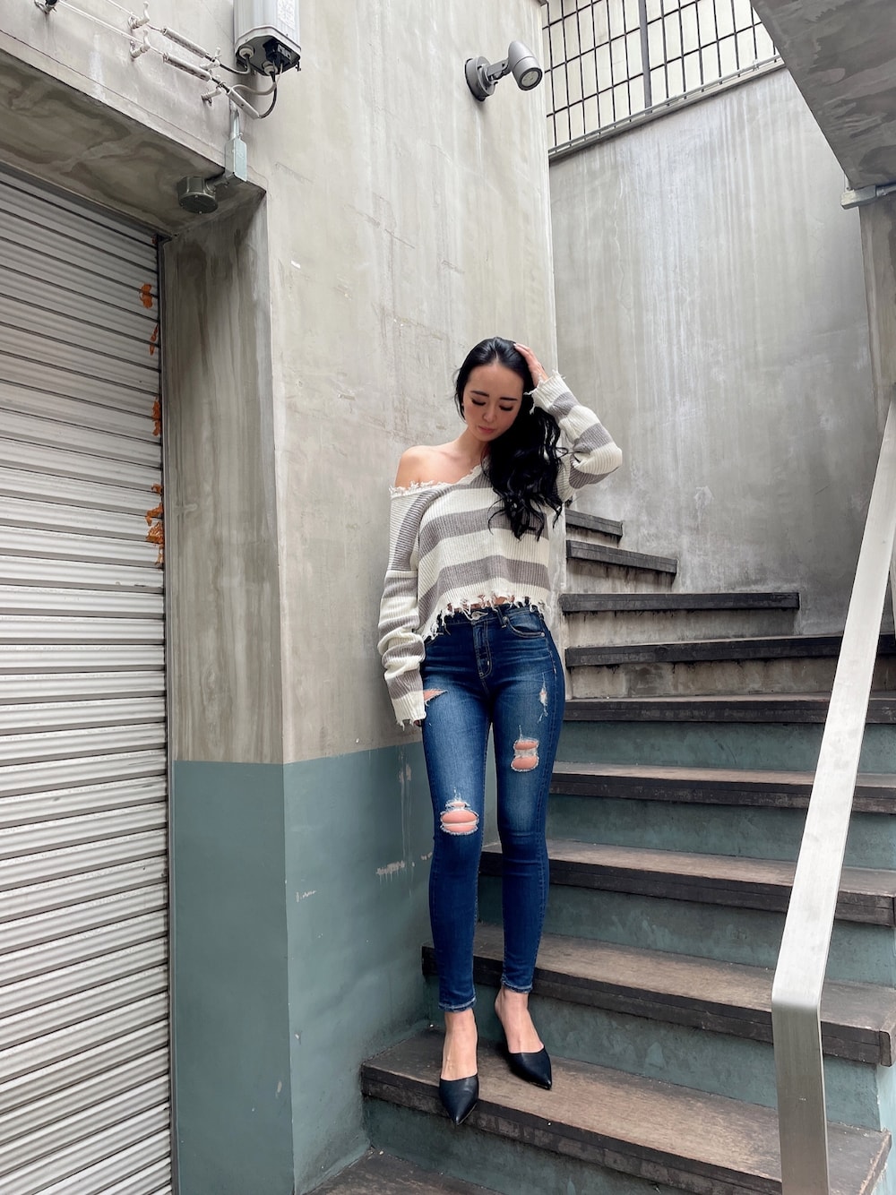 ブルー系のデニムパンツ、ブラック系のパンプス、グレー系のニット/セーターを着用したレディースの冬コーディネートの1枚目の写真