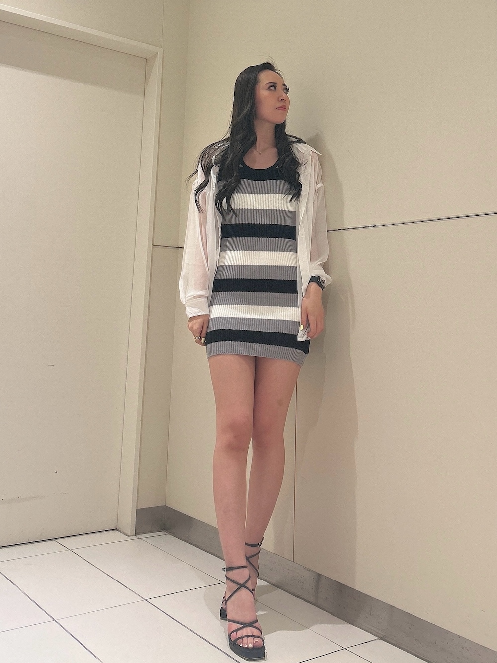 ブラック系のワンピース、ブラック系のサンダル、ホワイト系のシャツ/ブラウスを着用したレディースの夏コーディネートの1枚目の写真