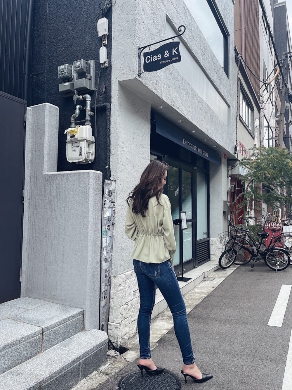 ブラック系のパンプス、ブルー系のデニムパンツ、グリーン系のシャツ/ブラウスを着用したレディースの冬コーディネートの1枚目の写真