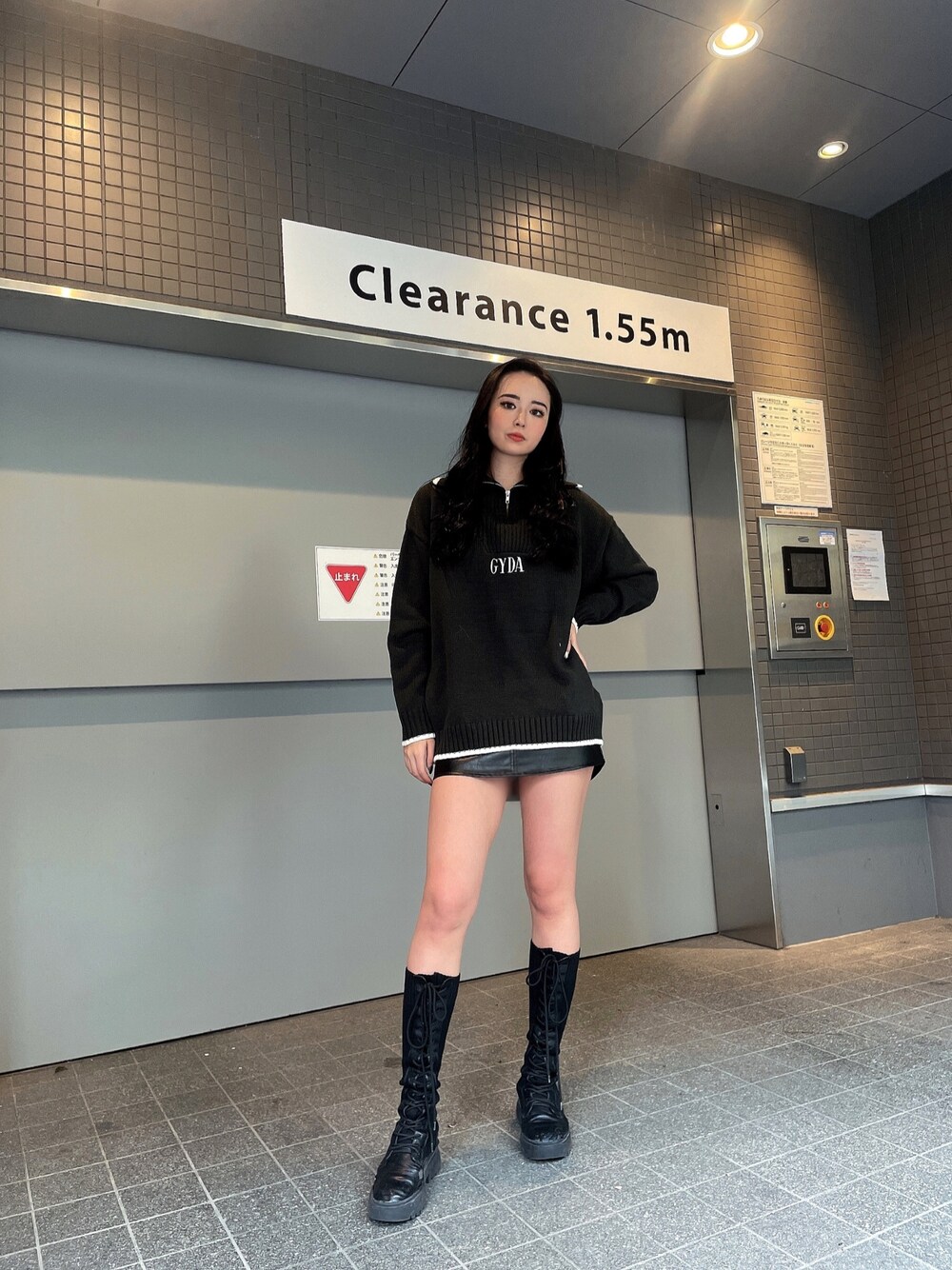 グレー系のニット/セーター、ブラック系のスカート、ブラック系のブーツを着用したレディースの冬コーディネートの1枚目の写真