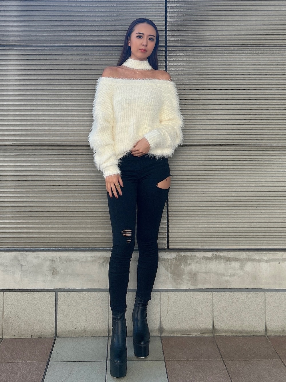 ホワイト系のニット/セーター、ブラック系のデニムパンツ、ブラック系のブーツを着用したレディースの秋コーディネートの1枚目の写真